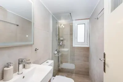 a white bathroom with a sink and a toilet at Irene's studio in Athens