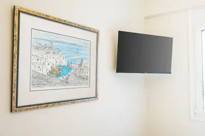 a framed picture hanging on a wall next to a window at Irene's studio in Athens