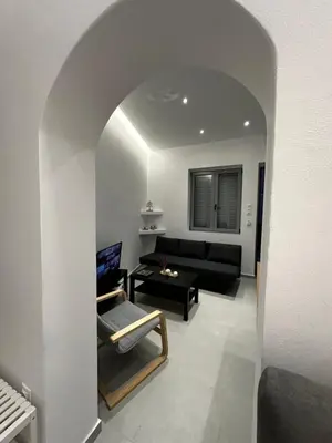 a living room with a black couch and a table at MMs house at Mikrolimano in Piraeus