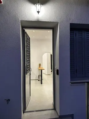 a door leading to a hallway with a table in a room at MMs house at Mikrolimano in Piraeus