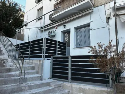 a house with stairs and a gate in front of it at MMs house at Mikrolimano in Piraeus