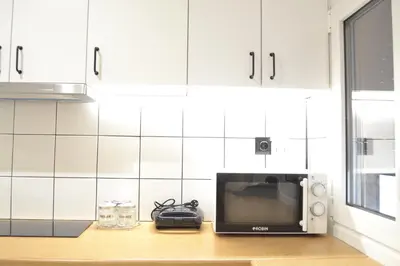 a microwave sitting on a counter in a kitchen at AIOLOS Pagrati Athens Hilton near METRO station in Athens