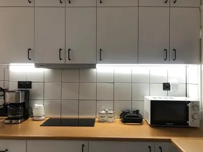 a kitchen with white cabinets and a counter with a microwave at AIOLOS Pagrati Athens Hilton near METRO station in Athens