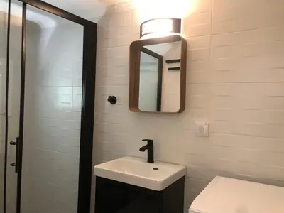 a bathroom with a sink and a mirror at AIOLOS Pagrati Athens Hilton near METRO station in Athens
