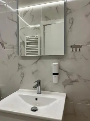 a bathroom with a white sink and a mirror at Family Suite by Zeussuites in Athens