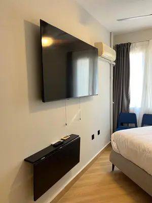 a bedroom with a bed and a television on the wall at Family Suite by Zeussuites in Athens