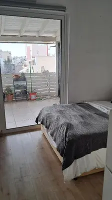 a bedroom with a bed and a large window at Minimal flat in Kalithea in Athens