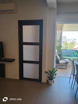 a door in a living room with a table and chairs at Minimal flat in Kalithea in Athens