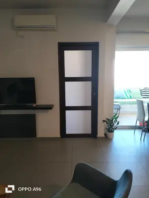 a living room with a door and a tv at Minimal flat in Kalithea in Athens