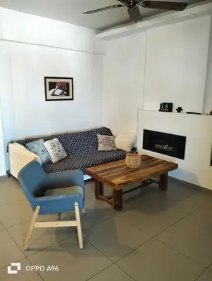 a living room with a couch and a table and a chair at Minimal flat in Kalithea in Athens