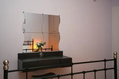 a vase of flowers on a shelf in front of a mirror at Chrysas apartment in Athens
