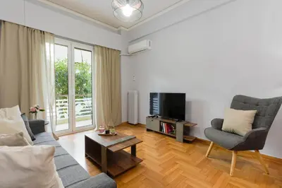 a living room with a couch and chairs and a tv at Chrysas apartment in Athens