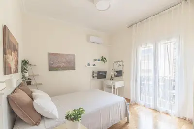 a white bedroom with a bed and a window at Central Cosy quite 28sm 5th floor balcony over garden 500m Metro Evangelismos in Athens