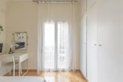 a white room with a window and a desk and a bed at Central Cosy quite 28sm 5th floor balcony over garden 500m Metro Evangelismos in Athens