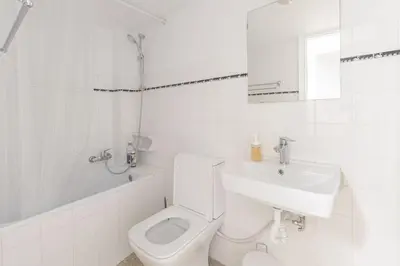 a white bathroom with a toilet and a sink at Central Cosy quite 28sm 5th floor balcony over garden 500m Metro Evangelismos in Athens
