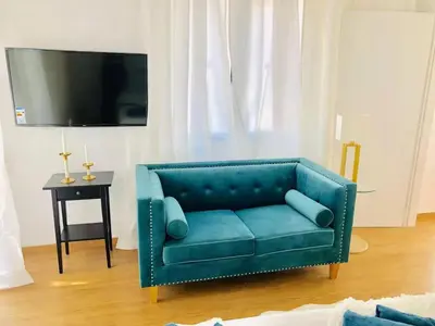 a blue couch in a living room with a tv at \u4f18\u5f02\u7684\u5730\u94c1\u65c1\u516c\u5bd3 in Athens