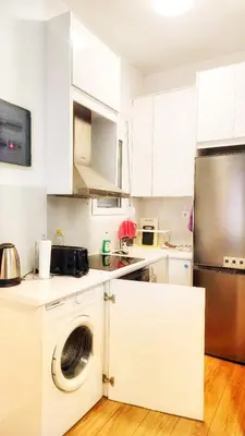 a kitchen with white cabinets and a washing machine at \u4f18\u5f02\u7684\u5730\u94c1\u65c1\u516c\u5bd3 in Athens