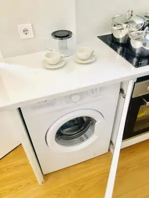a washing machine under a counter in a kitchen at \u4f18\u5f02\u7684\u5730\u94c1\u65c1\u516c\u5bd3 in Athens
