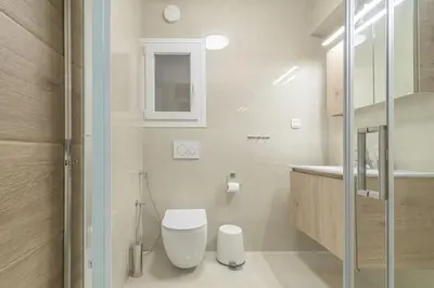 a white bathroom with a toilet and a sink at Golden Studio 47sm in Athens Central Pangrati 1km Metro Evangelismos in Athens