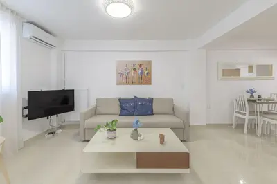 a living room with a couch and a tv at Golden Studio 47sm in Athens Central Pangrati 1km Metro Evangelismos in Athens