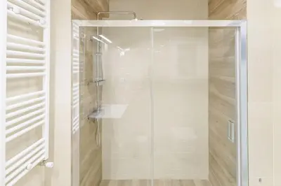 a shower with a glass door in a bathroom at Golden Studio 47sm in Athens Central Pangrati 1km Metro Evangelismos in Athens