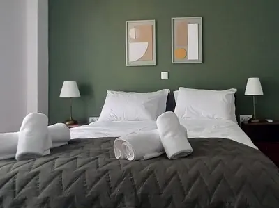 a bedroom with a large bed with white sheets and pillows at Modern 2 bedroom Apartment near Kallimarmaro and Alsos in Athens