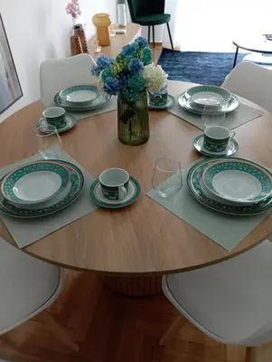a table with plates and cups and a vase of flowers at Modern 2 bedroom Apartment near Kallimarmaro and Alsos in Athens