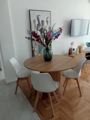 a dining room table with white chairs and a vase with flowers at Modern 2 bedroom Apartment near Kallimarmaro and Alsos in Athens
