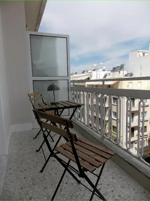 a balcony with two chairs and a table on a balcony at Modern 2 bedroom Apartment near Kallimarmaro and Alsos in Athens