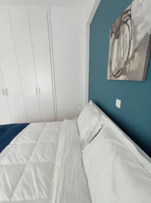 a white bed in a room with a painting on the wall at Funky & trendy 1 BDR aparment in Athens