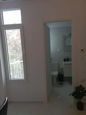 a white room with a window and a bathroom at Funky & trendy 1 BDR aparment in Athens