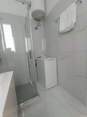 a white bathroom with a shower and a toilet at Funky & trendy 1 BDR aparment in Athens