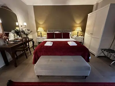 a bedroom with a red bed and a desk and a desk at Air Suite in Spáta