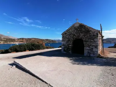 an old stone church with a cross on a road at Sea View Serenity in Athens in Anavissos