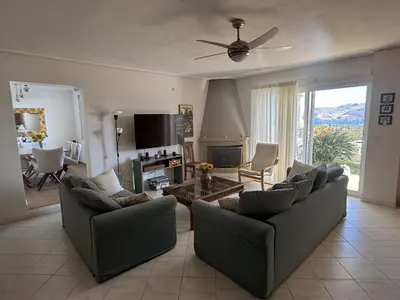 a living room with two couches and a tv at Sea View Serenity in Athens in Anavissos