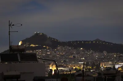 a view of a city at night with a mountain at Pangrati Gem views to Lycabettus in Athens