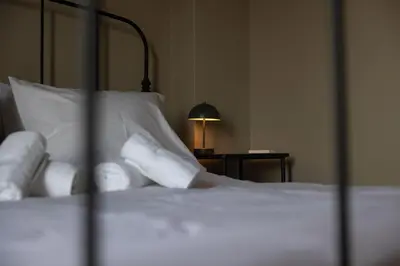 a bed with white pillows and a lamp on a table at Pangrati Gem views to Lycabettus in Athens