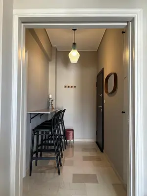 a hallway with a bar with black stools at Pangrati Gem views to Lycabettus in Athens