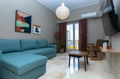 a living room with a blue couch and a table at Pangrati Gem views to Lycabettus in Athens