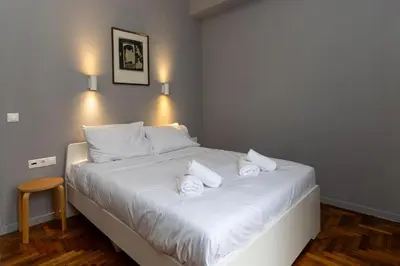 a bedroom with a white bed with three pillows at ERMES 2-BD Retreat with Acropolis view in Athens