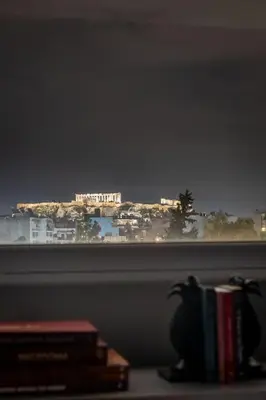a view of a city from a window with books at ERMES 2-BD Retreat with Acropolis view in Athens