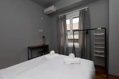 a bedroom with a white bed with a window at ERMES 2-BD Retreat with Acropolis view in Athens