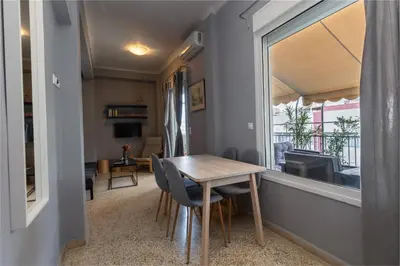 a small dining room with a table and a window at Jacuzzi Patio & Acropolis view 2-BD Retreat in Athens