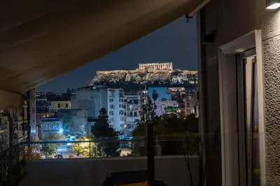 a view of a city at night from a window at Jacuzzi Patio & Acropolis view 2-BD Retreat in Athens