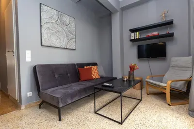 a living room with a couch and a table at Jacuzzi Patio & Acropolis view 2-BD Retreat in Athens