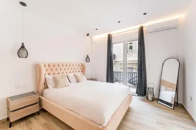 a white bedroom with a large bed and a window at Alma Suite - close to Acropolis in Athens