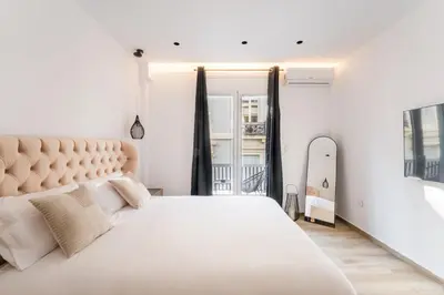 a white bedroom with a large bed and a window at Alma Suite - close to Acropolis in Athens