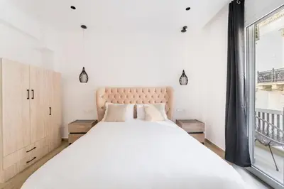 a bedroom with a large white bed with a window at Alma Suite - close to Acropolis in Athens