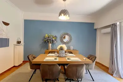 a dining room with a table and a blue wall at National Park in Athens