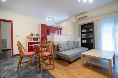 a living room with a couch and a table and chairs at Mesogion 3 person apartment by MPS in Athens